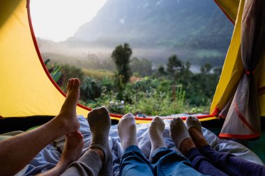 Yakın arkadaş grubu ayak aşağı sakin ol yalan ve bacak üzerinde çadır ve Dağı'nda seyir battaniyeye çapraz gündoğumu zaman kamp tatil tatil görüntüleyebilirsiniz