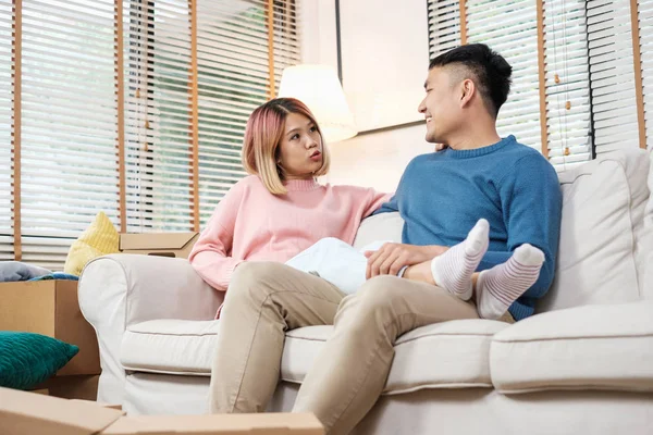 Asian couple planning to decorate house after moving to new home,sitting on sofa with relax emotion