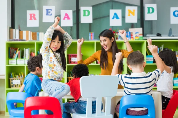 Glad asiatiska kvinnliga lärare och blandad ras barn i klassrummet, typ — Stockfoto