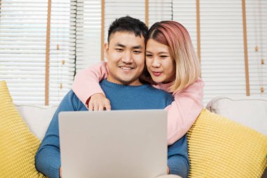 Asya çift izlerken video laptp oturma odasında kanepede canlı