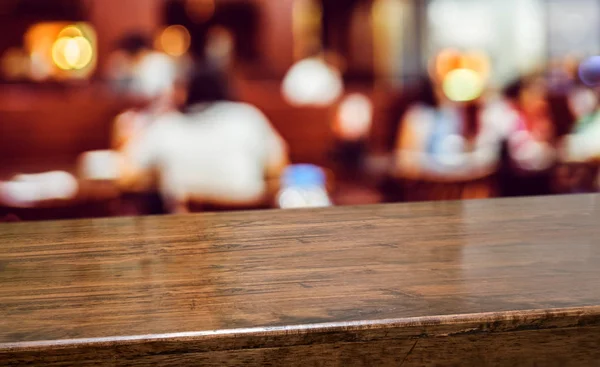 Mesa de madeira com pessoas jantar no restaurante desfoque background.Empt — Fotografia de Stock