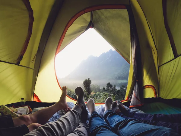recreation at mountain in camping tent.group of feet lying down