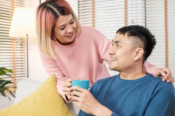 Happy Asian par dricker kaffe sitter i soffan i huset. älskare — Stockfoto