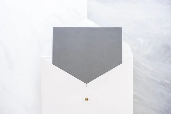 Visão superior do cartão cinza em branco no envelope branco em duas camadas passo o — Fotografia de Stock