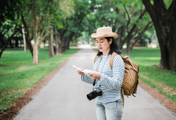 亚洲妇女背包旅行使用地图时，在雨中旅行 — 图库照片