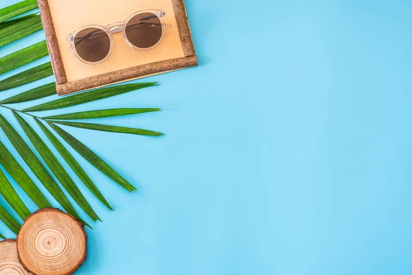 Bandeira azul de verão com grama de quadro de madeira, óculos de sol, concha — Fotografia de Stock