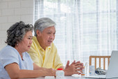 Asiatisches Paar Senioren nutzen Laptop-Videokonferenz mit Arzt abo
