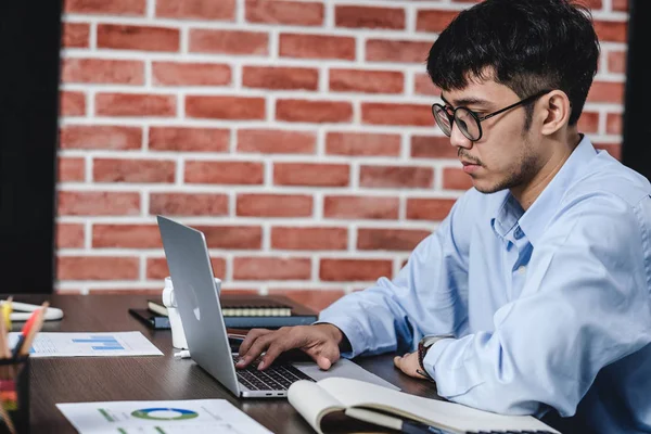 Asiatisk affärsman som tittar på arbetet med laptop på skrivbordet med — Stockfoto