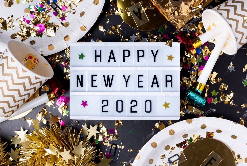 Happy new year 2020 on light box with party cup,party blower,tin