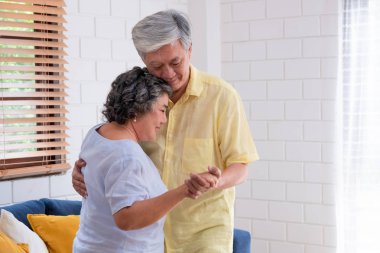 asyalı yaşlılar çift evde oturma odasında dans keyfini.aging 
