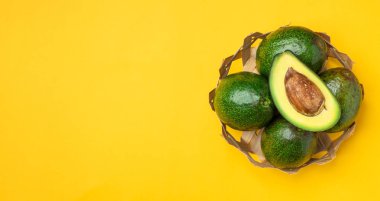 organik avokado sepette tohum ve bütün meyve ile yarım kesilmiş