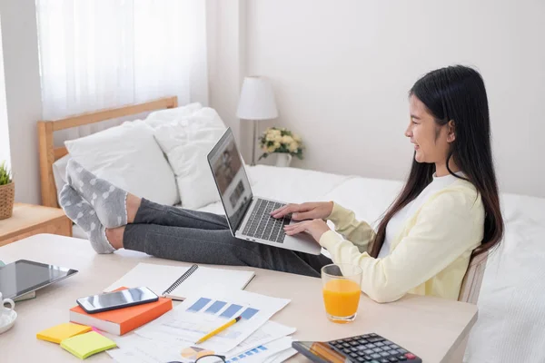 Asian female freelancer working on laptop computer on table at b