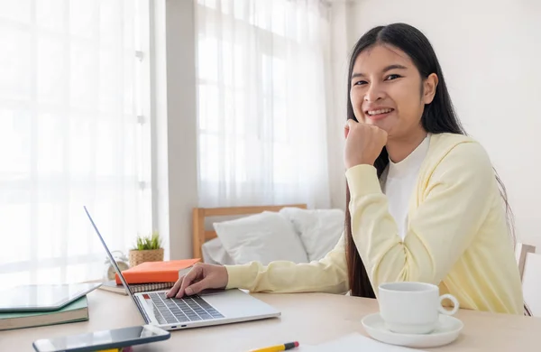 Asiatico femmina freelancer lettura relazione su laptop e annotare no — Foto Stock