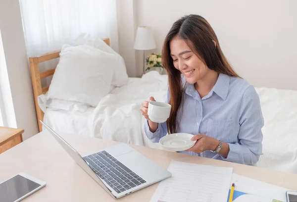 Asiatico businesswoman bere caffè e mentre lavoro con lapto — Foto Stock