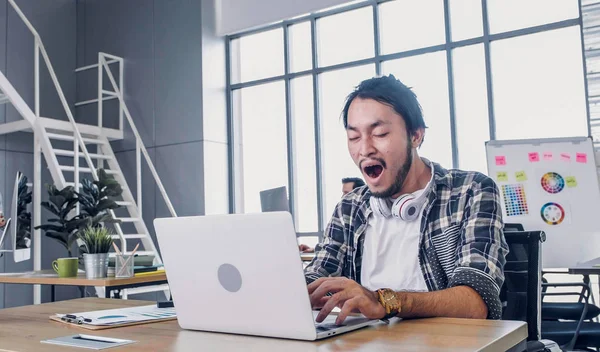 Kreativ designer gäspa medan du arbetar hårt och tråkigt med laptop — Stockfoto