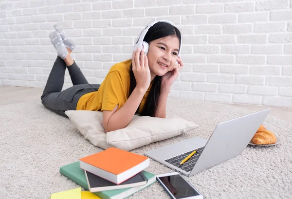 Asiatico femmina ascoltare musica e utilizzare computer portatile per lavorare a — Foto Stock