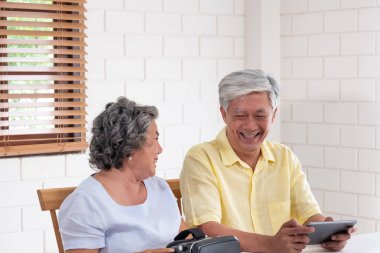 Asyalı üst düzey çift sanal realtiy gözlük kulaklık ve tablet vr video izlerken oynamak ve evde oturma odasında birlikte eğlenmek.senior teknoloji ile.evde yaşlanma