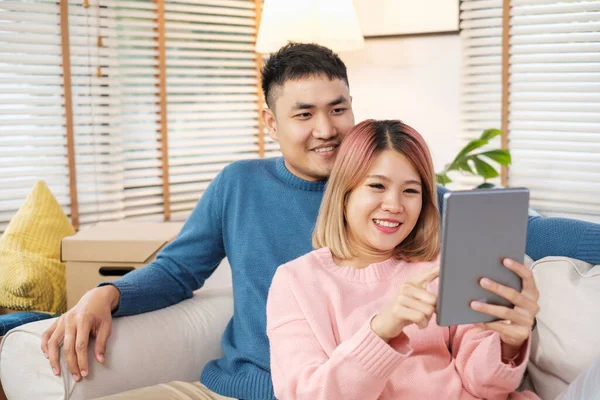 Mutlu Asyalı Çift Tablet Kullanarak Evdeki Kutuyu Taşımayı Bitirince Kanepenin — Stok fotoğraf