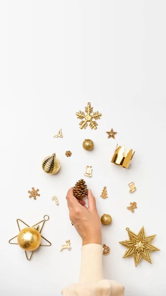 Christmas banner background.woman hand decoration golden color xmas items in Christmas tree shape on table.vertical mockup banner 16-9 ratio for advertise on mobile social media