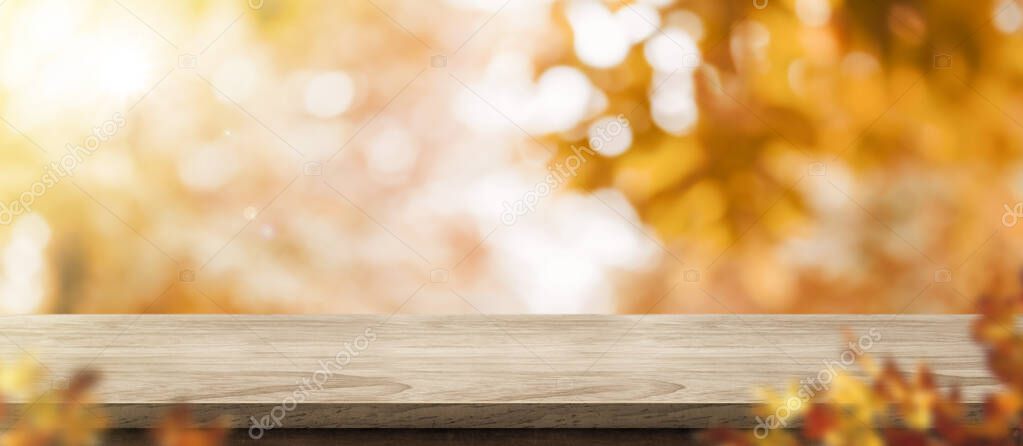 Autumn background.Empty old rustic wood table with blur forest tree with sunlight,Autumn fall backdrop, banner for product display for advertise on online,thanksgiving concept