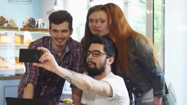 Un bell'uomo che parla di selfie con i suoi amici alla caffetteria — Video Stock