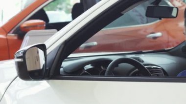 Neşeli genç yakışıklı adam yeni arabada oturan kameraya gülümseyen