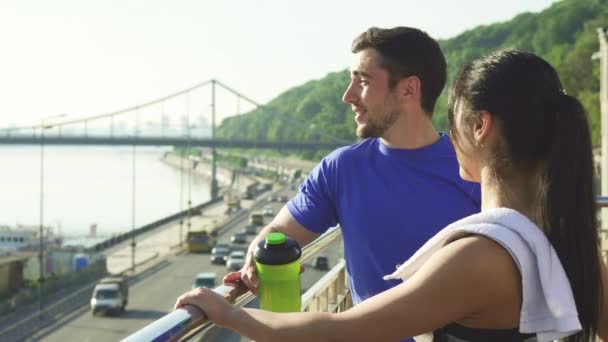 Beau couple sportif relaxant après l'entraînement matinal dans une ville urbaine — Video
