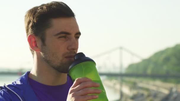 Gros plan d'un beau jeune homme qui boit de l'eau après s'être entraîné — Video