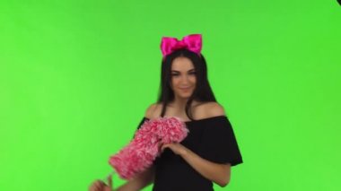 Pembe fiyonk bir silgi ile poz giyen genç güzel kadın