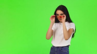 Gorgeou genç kadın güvenle görünümlü pembe gözlüklerini koyarak