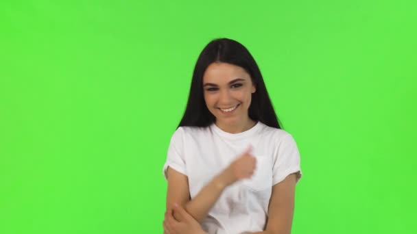 Счастливая красивая женщина показывает большие пальцы на зеленом фоне — стоковое видео