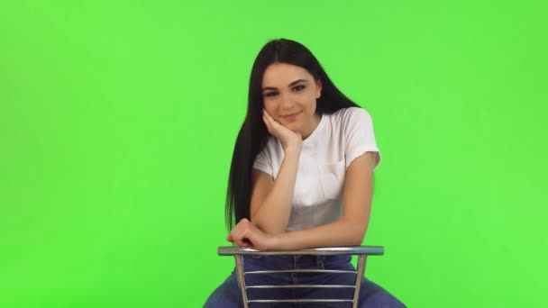 Hermosa chica adolescente feliz sentado en una silla sonriendo a la cámara — Vídeos de Stock