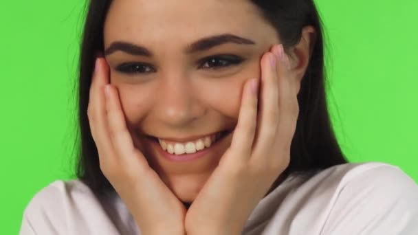 Közelről egy gyönyörű tizenéves lány mosolyogva arcát kezével köpölyözőkészlet — Stock videók