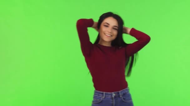Glückliche junge schöne Frau lächelt und spielt mit ihren Haaren — Stockvideo
