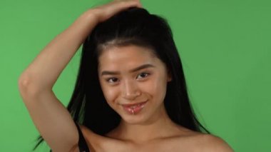 Mutlu genç güzel Asyalı kadın saçları ile oynarken çarpıcı