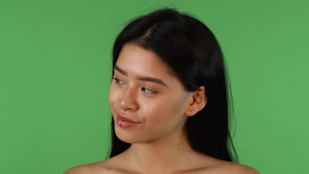 Азиатская женщина смотрит в стороны, а затем улыбается камере — стоковое видео