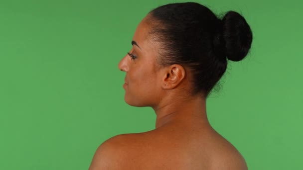 Prachtige Afrikaanse vrouw die lacht naar de camera over haar schouder — Stockvideo