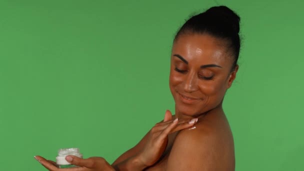 有吸引力的成熟妇女使用身体乳液在绿色背景下 — 图库视频影像
