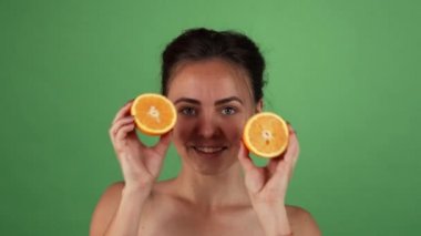 Holding portakal yeşil chromakey üzerinde gülümseyen güzel mutlu erkek