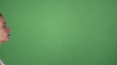 Genç kadın yeşil chromakey arka planda çığlık