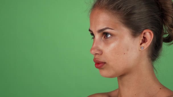 Estudio de una hermosa joven con la piel impecable mirando a la cámara — Vídeos de Stock