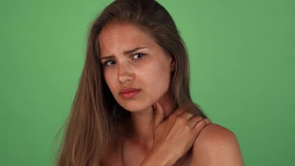 Hermosa mujer joven que tiene dolor de espalda posando en chromakey — Vídeo de stock