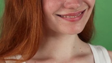 Kırmızı saçlı kadın mutlu yeşil chromakey arka plan üzerinde gülümseyen