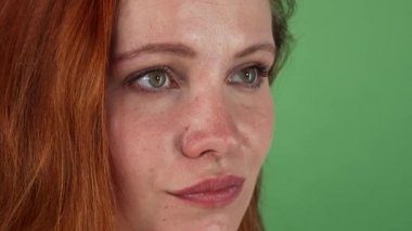 Genç güzel kızıl saçlı kadın kameraya bakıyor