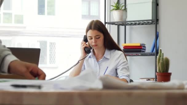 Designer feminino atraente atender o telefone no escritório — Vídeo de Stock