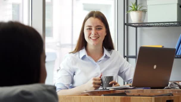 Preciosa mujer de negocios alegre hablando con su colega en el trabajo — Vídeo de stock