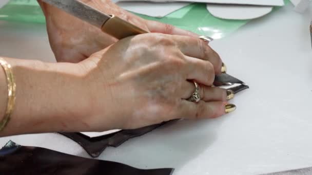 Kvinnlig skomakare skärande läderbitar på hennes workshop — Stockvideo
