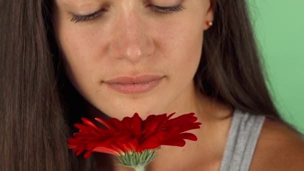 Красива молода жінка, радісно посміхаючись, пахне квіткою — стокове відео