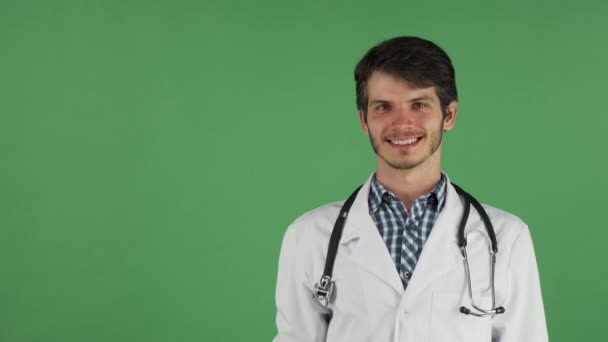 Médico masculino sonriendo sosteniendo espacio de copia en su mano — Vídeos de Stock