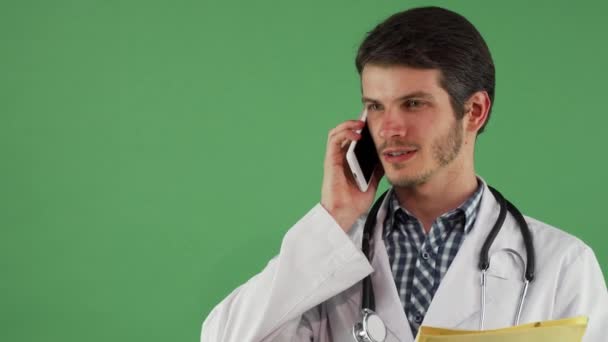 Бородатый врач говорит по телефону, выглядит сосредоточенным. — стоковое видео